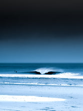 Load image into Gallery viewer, A blue photograph with two surfers in the North sea next to a breaking wave viewed from the beach
