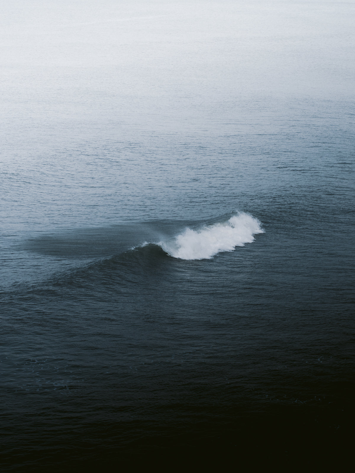A zoomed-in, mysterious breaking wave in the North Sea, perfect for minimalistic surf photography prints from The Netherlands that brings a calm and peaceful vibe.