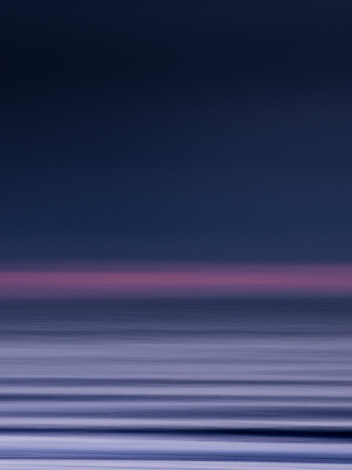 Abstract North Sea photograph with purple hues from a sunset, created using a panning technique. Unique and elegant surf art.
