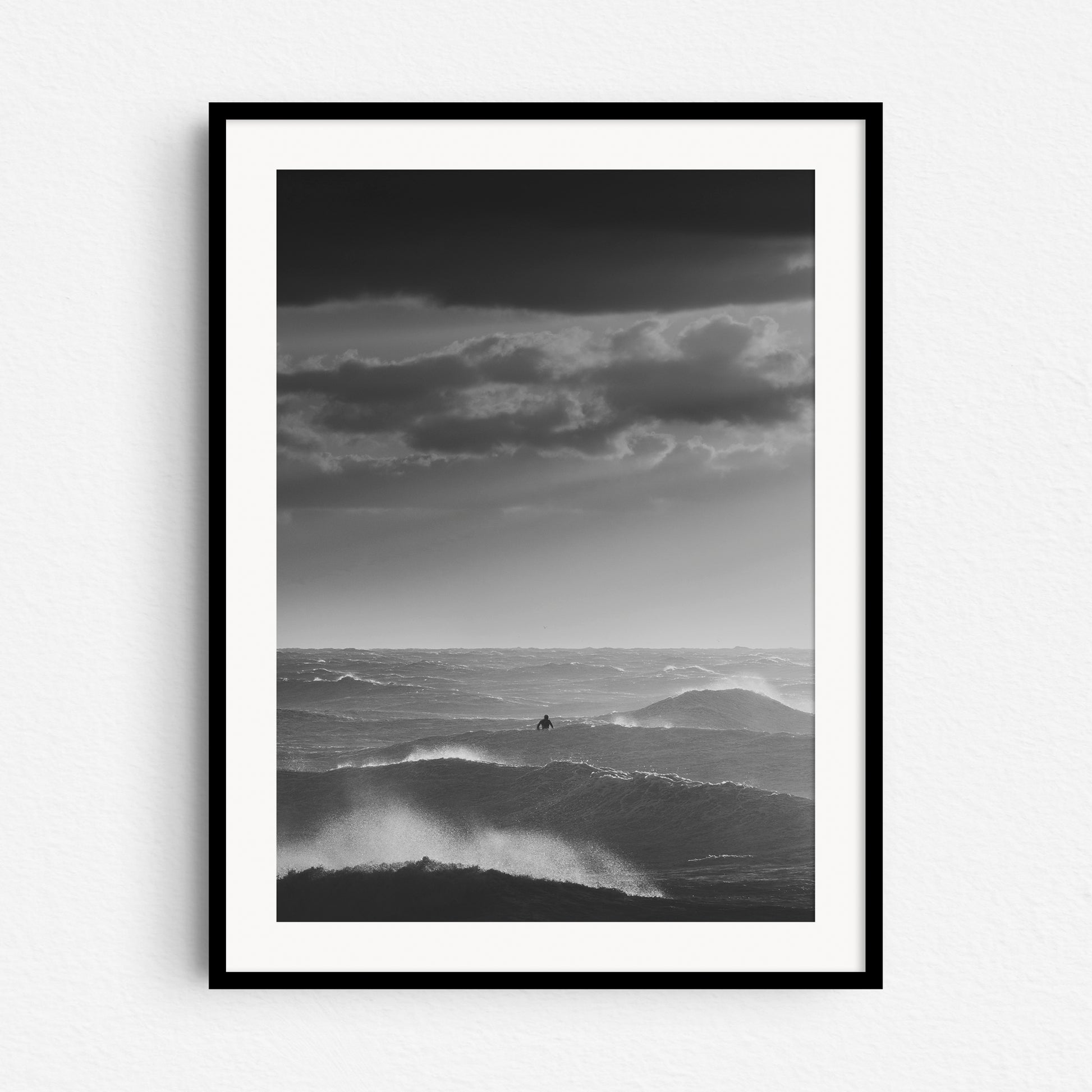 Dutch surf photography of a rough sea, framed in black wood.