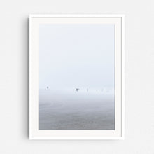 Load image into Gallery viewer, A surfer in a blizzard on the Scheveningen beach, print in a white wooden frame.
