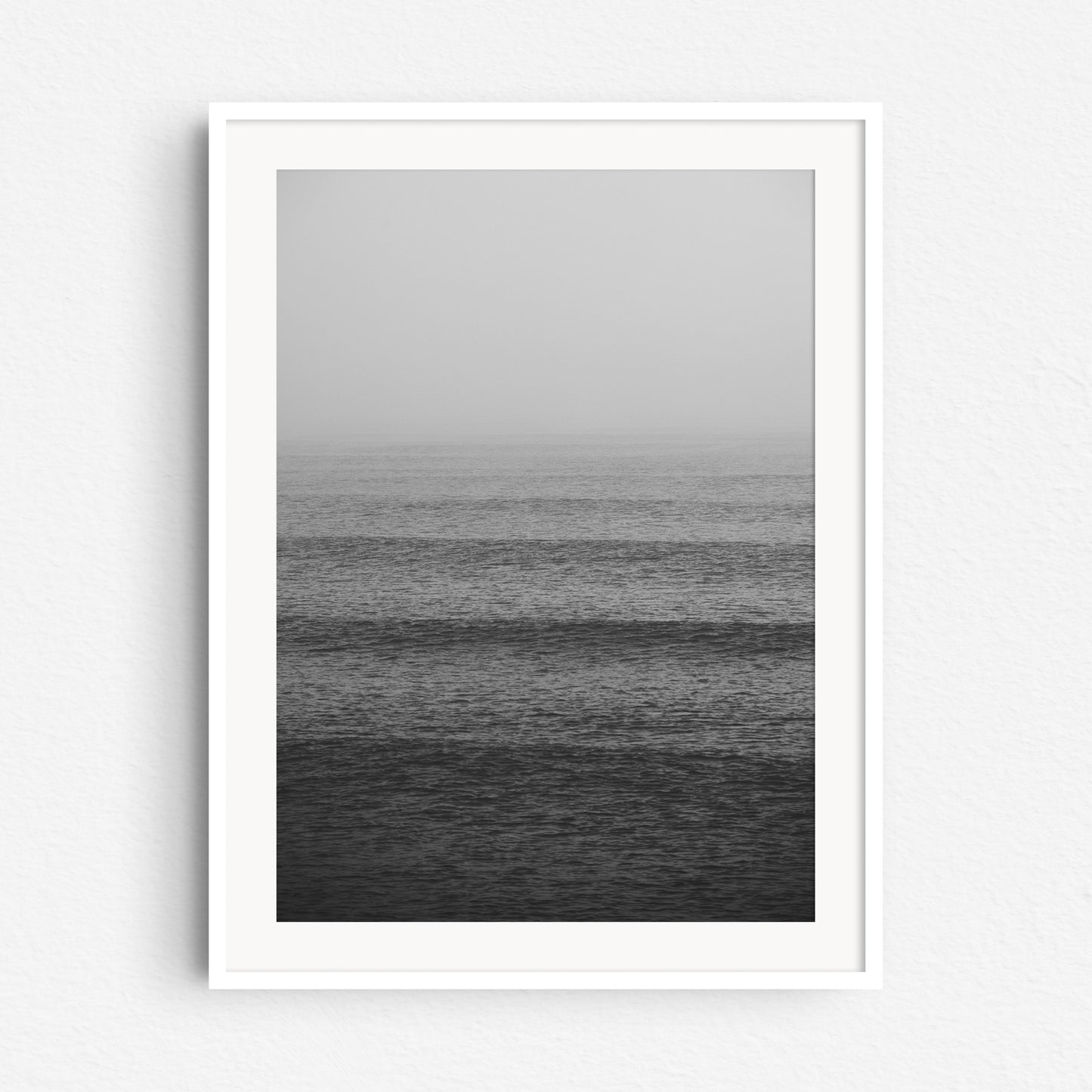 Minimalistic photography at the Scheveningen coast in a white wooden frame.