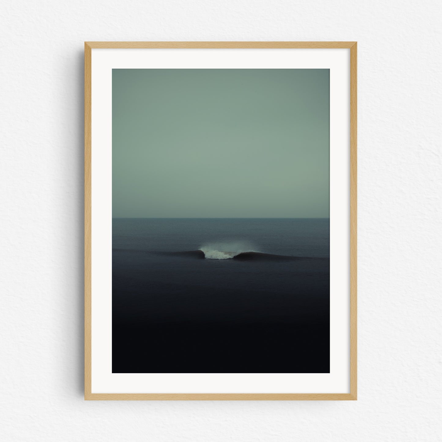 Turquoise print of a wave in the Dutch North sea, framed in natural wood.