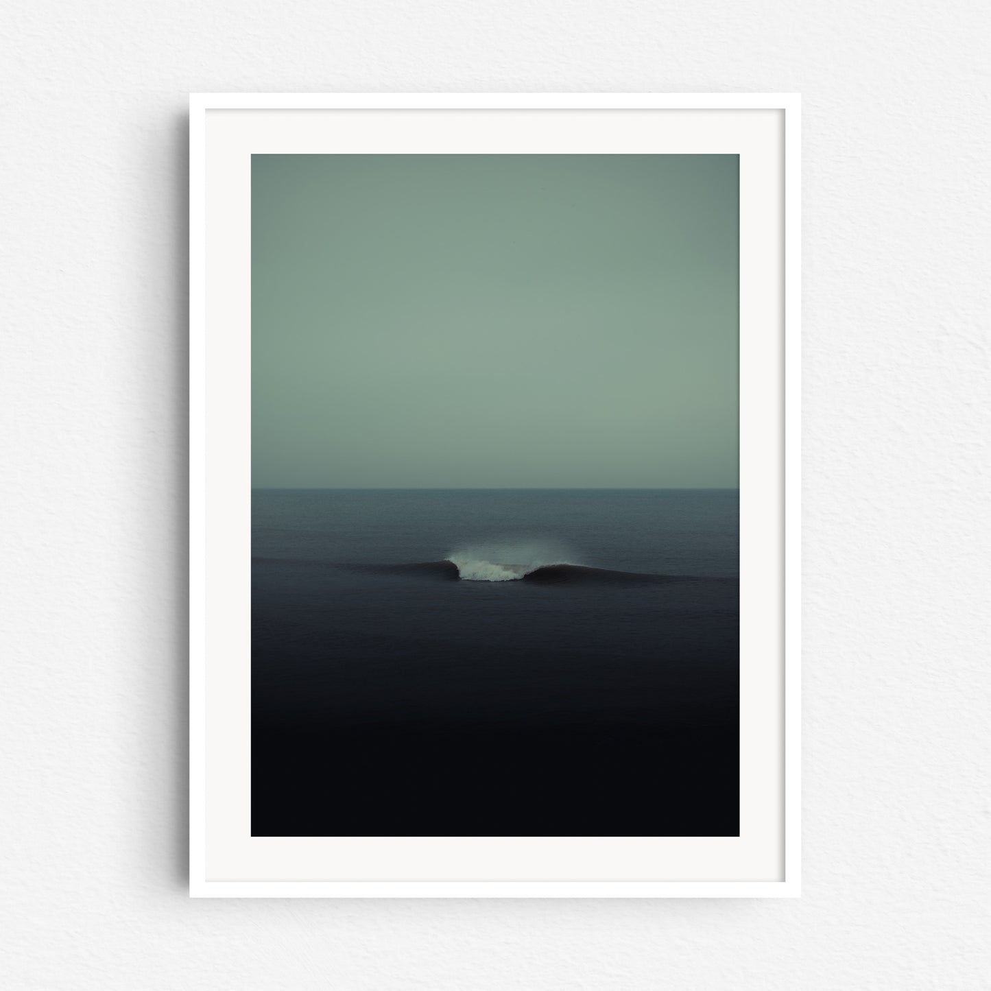 Turquoise surf art in a white wooden frame, captured by Jop Hermans.