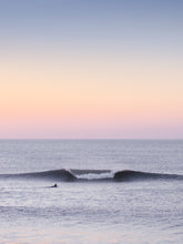 Load image into Gallery viewer, Surfer in a pastel coloured evening sky with a big wave, captured by Jop Hermans.
