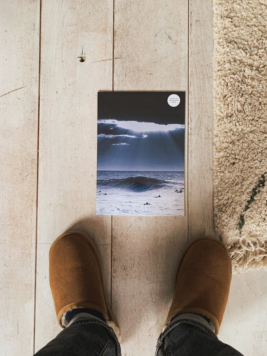 An A4 surf print of a large North Sea wave  with heavy skies, captured by Jop Hermans.