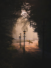 Load image into Gallery viewer, A surfer crosses the road in Scheveningen, carrying a longboard in a misty landscape while the sun was rising.
