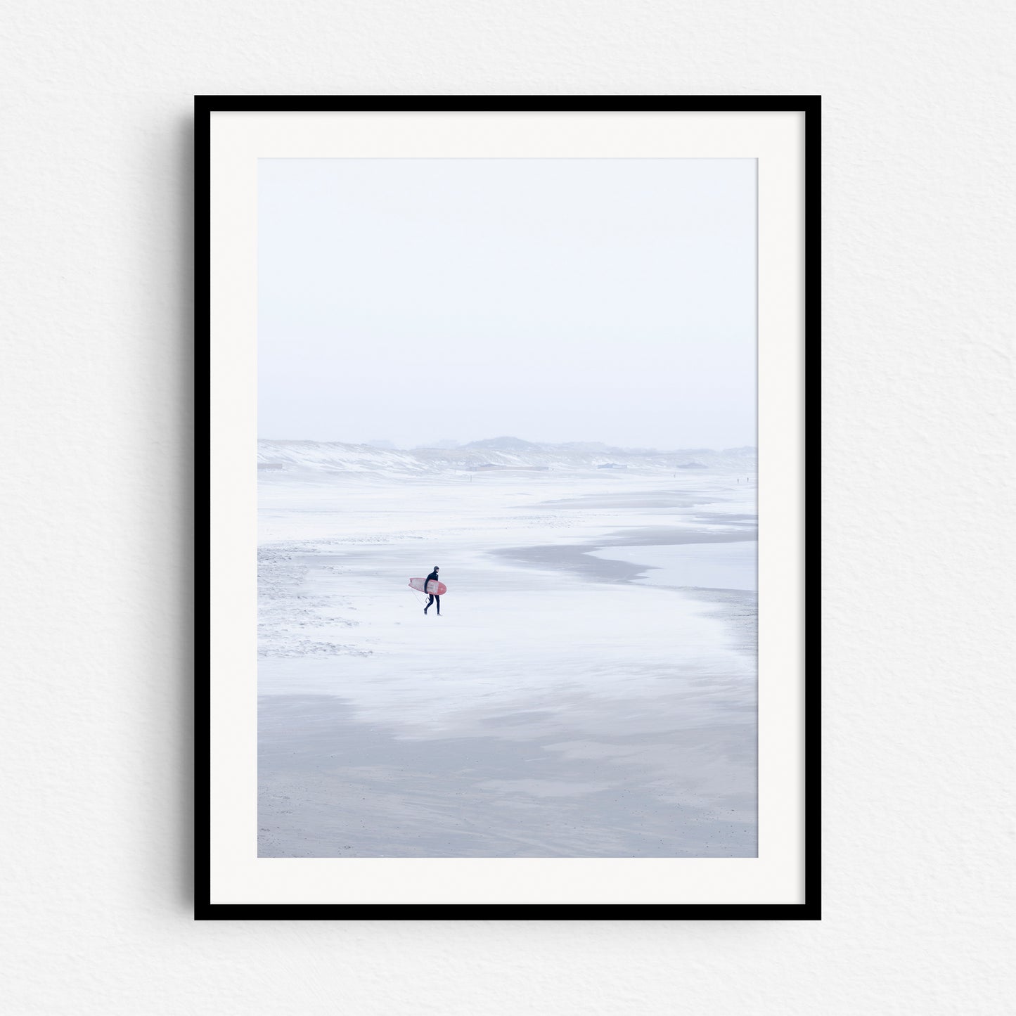 A North Sea winter surf print in a black wooden frame.