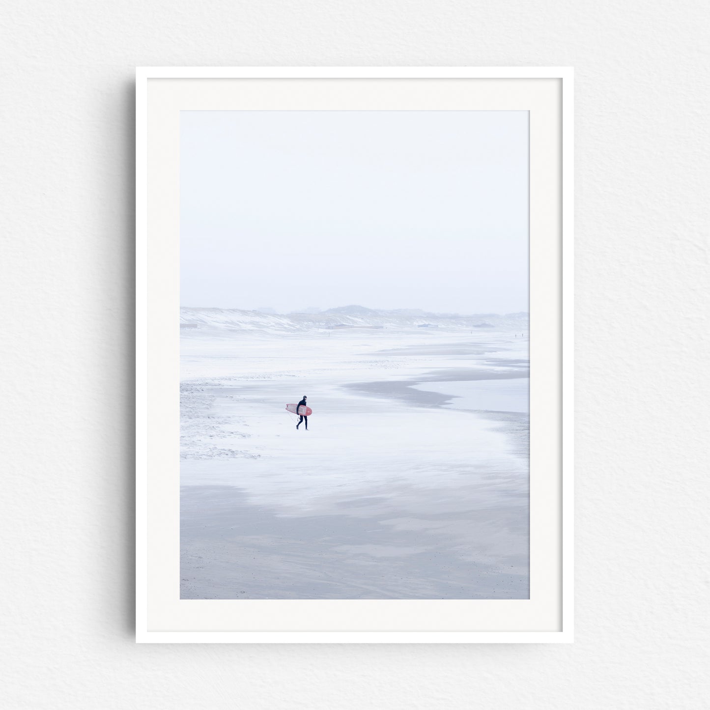 Photo print of a winter scene on the Scheveningen beach in a white wooden frame.