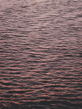 Load image into Gallery viewer, A photograph of the North Sea surface showing endless ripples coloured by the sunset, captured by Jop Hermans.
