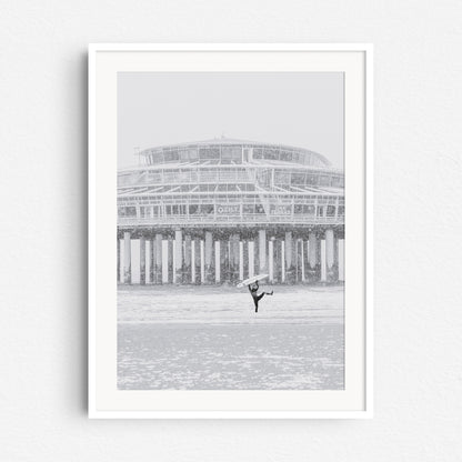 White wooden frame with a surf photo of a happy surfer in a snwostorm.