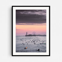 Load image into Gallery viewer, Surfers during sunset in front of the iconic Scheveninge pier, captured by Jop Hermans, framed in black wood.
