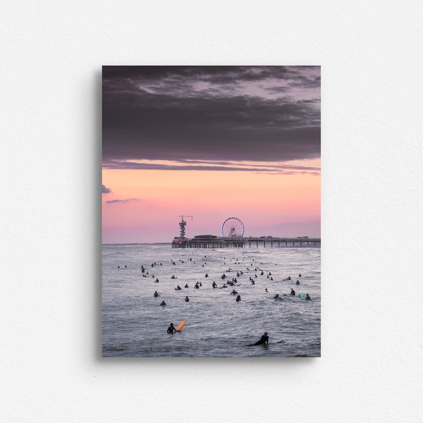 A crowded North Sea with surfers in The Hague underneath a beautiful orange sunset. Printed on dibond for lasting artwork