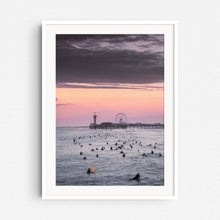 Load image into Gallery viewer, Orange sunset over a crowded North Sea, with the Scheveningen pier and ferris wheel in the background, framed in white wood.
