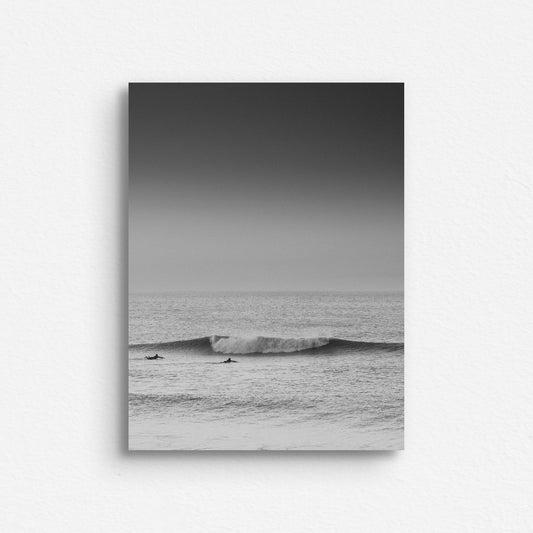 Two surfers paddle towards a broken wave in the North Sea. Printed on Dibond, captured by Jop Hermans.