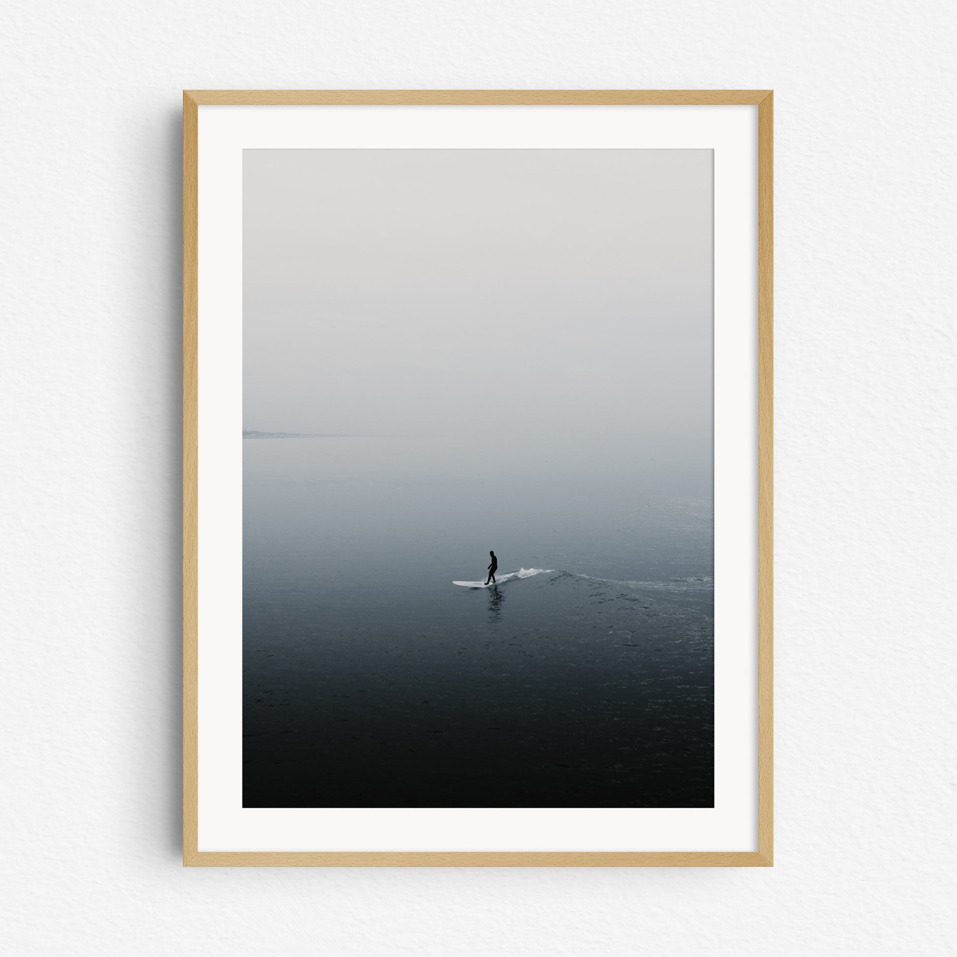 The shade of a surfer reflects on the North Sea surface, framed in natural wood, ideal for surf photography and nature photography fans. Artwork created by Jop Hermans