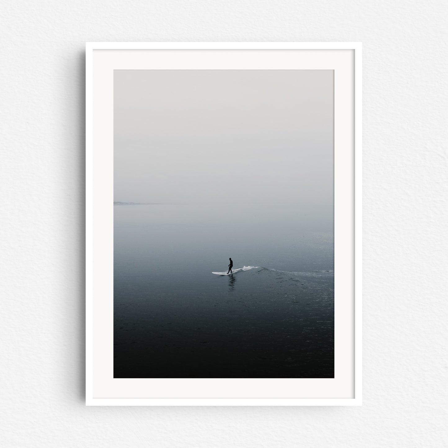 The calming silhouette of a surfer in the North Sea, framed in white wood, a peaceful addition for North Sea Surf Photos lovers.