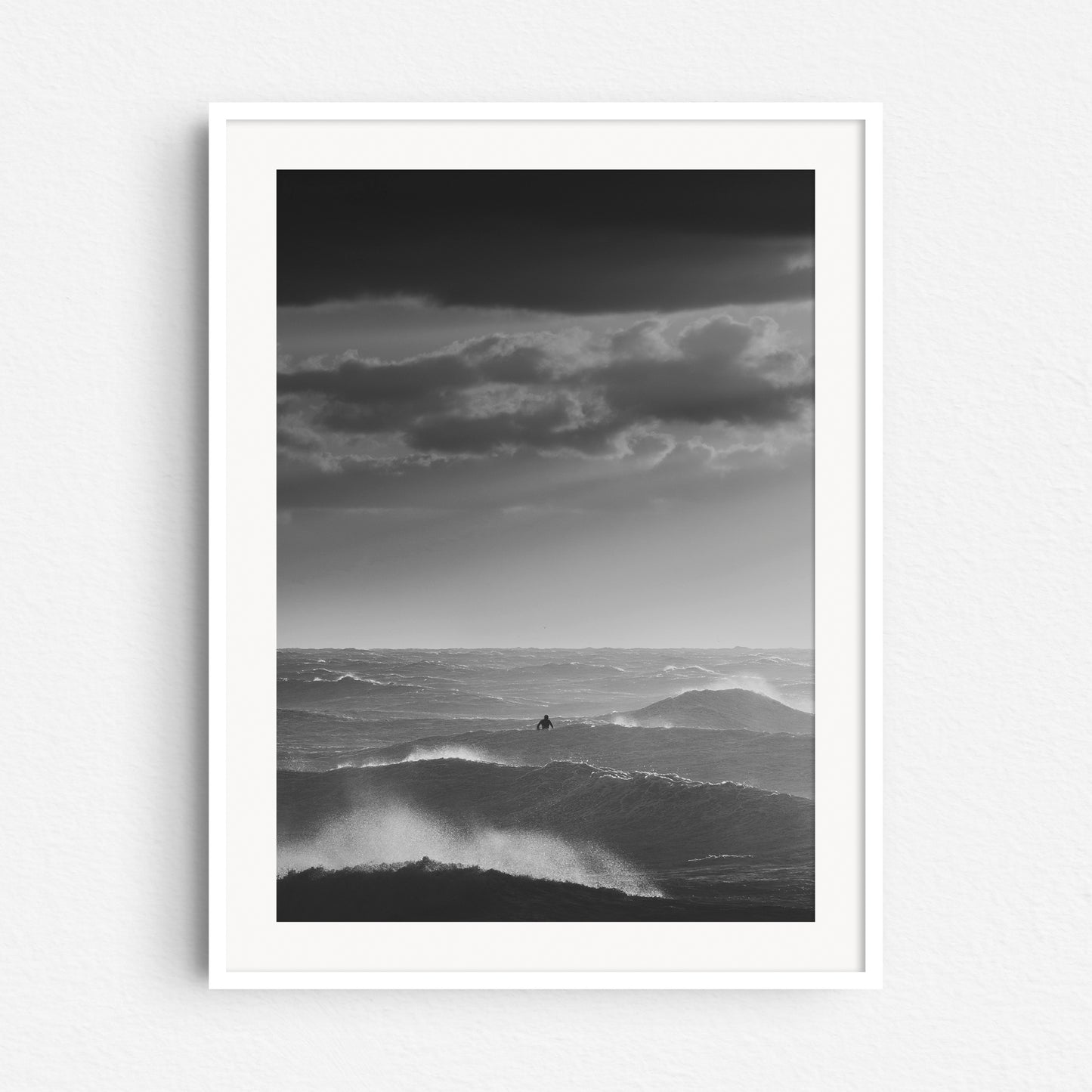 A rough sea black and white print in a white wooden frame, captured by Jop Hermans