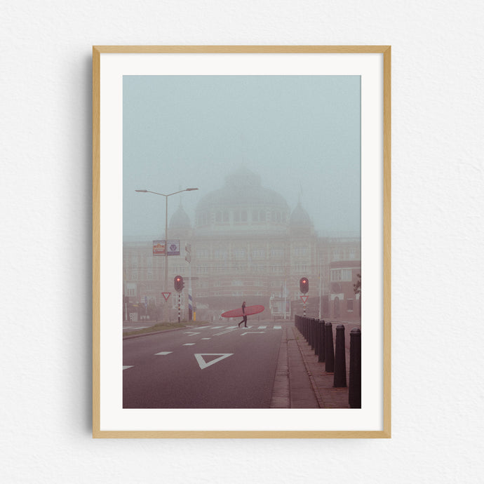 Surfer walking in front of the Grand Kurhaus hotel in Scheveningen. Surf print in a natural wooden frame.