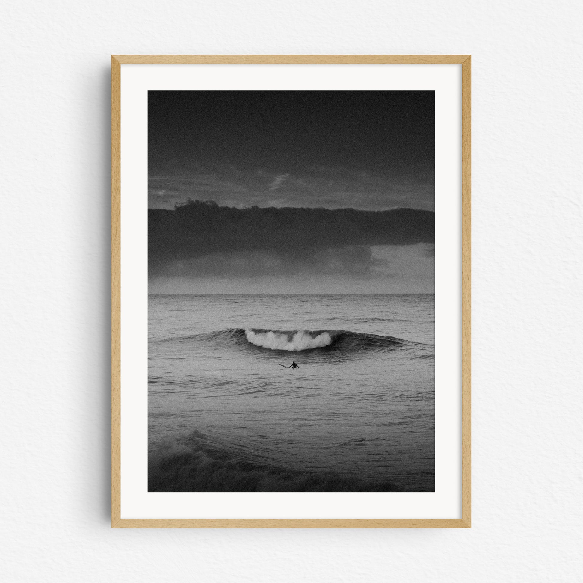 Black and white surf photography in a natural wooden frame.