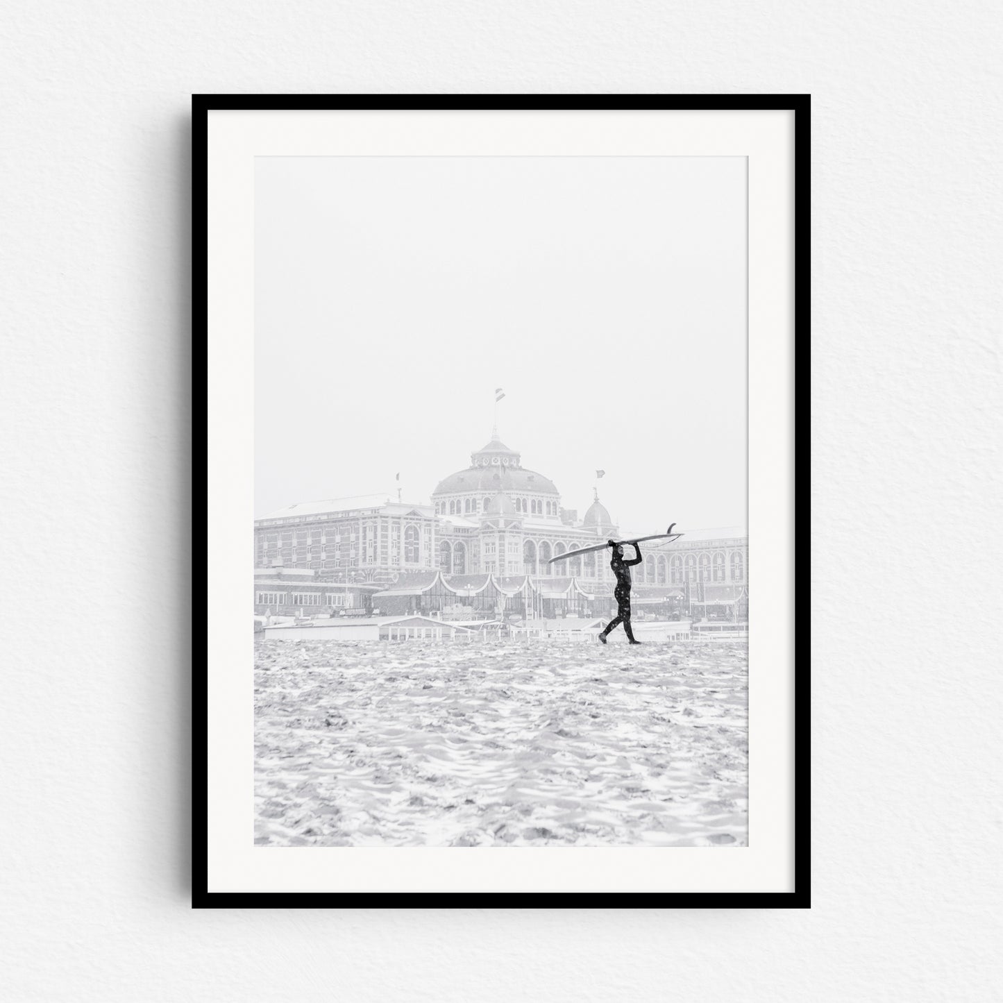 Winter surfer in The netherlands in front of the Scheveningen Kurhaus Hotel, framed in black wood.