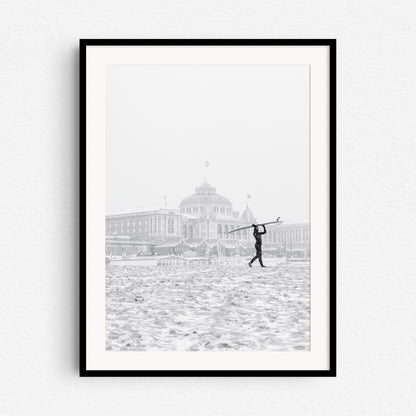 Winter surfer in The netherlands in front of the Scheveningen Kurhaus Hotel, framed in black wood.