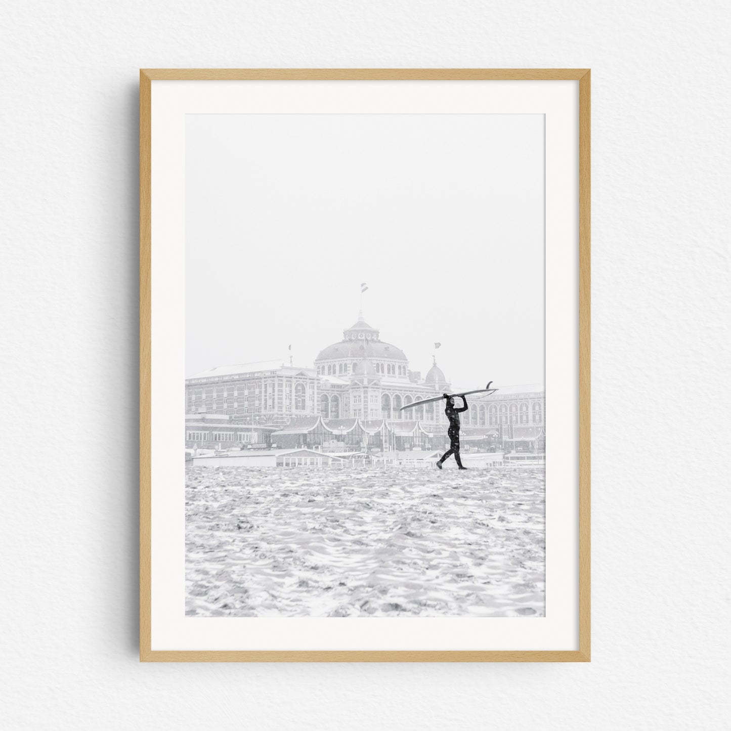 Winter surf photography in Scheveningen with the Kurhaus hotel as a backdrop, framed in natural wood.