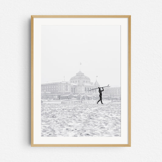 Winter surf photography in Scheveningen with the Kurhaus hotel as a backdrop, framed in natural wood.