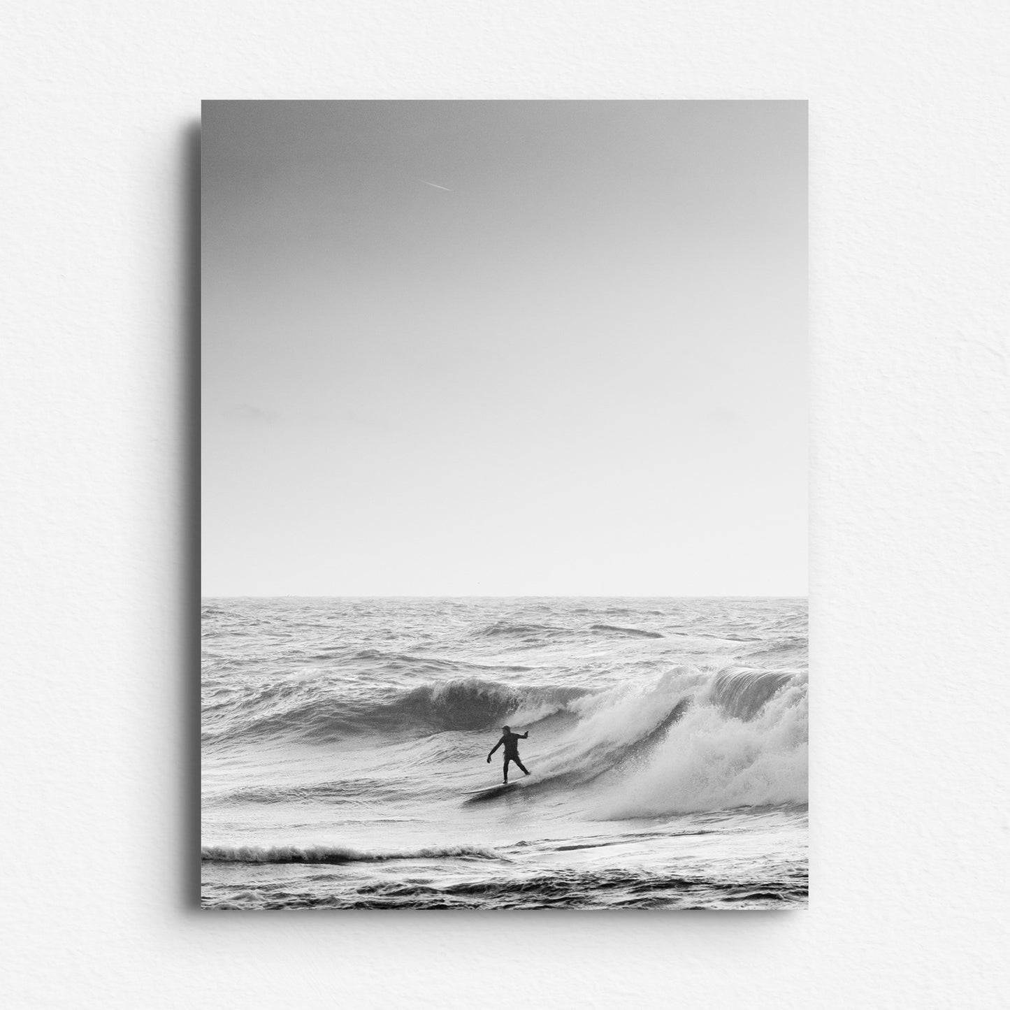 Black and white photo of a surfer on a wave, printed on Dibond for a modern and sleek. By affordable wall art in Jop's store!