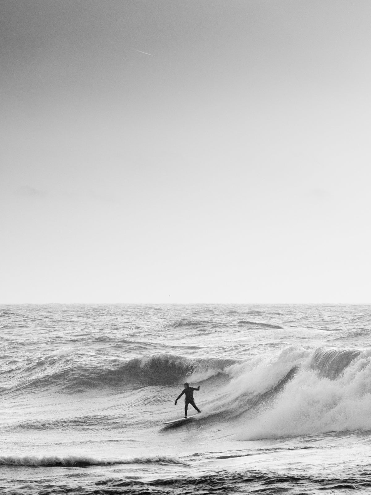 Surfer silhouette on a North Sea wave, perfect for Surf Photography Prints Netherlands and wall art enthusiasts.