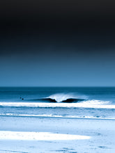 Load image into Gallery viewer, A blue photograph with two surfers in the North sea next to a breaking wave.  Minimalist coastal artwork perfect for your home.
