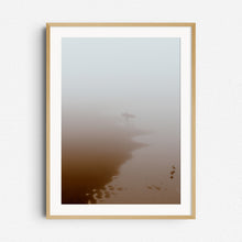 Load image into Gallery viewer, Print in natural wooden frame: Serene beach scene with a surfer leaving the water, framed in natural wood to enhance the calming aesthetic.
