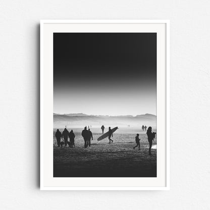 High contrast black and white photo of a beach scene with a longboarder, framed in white wood, perfect for elegant Wall decoration.