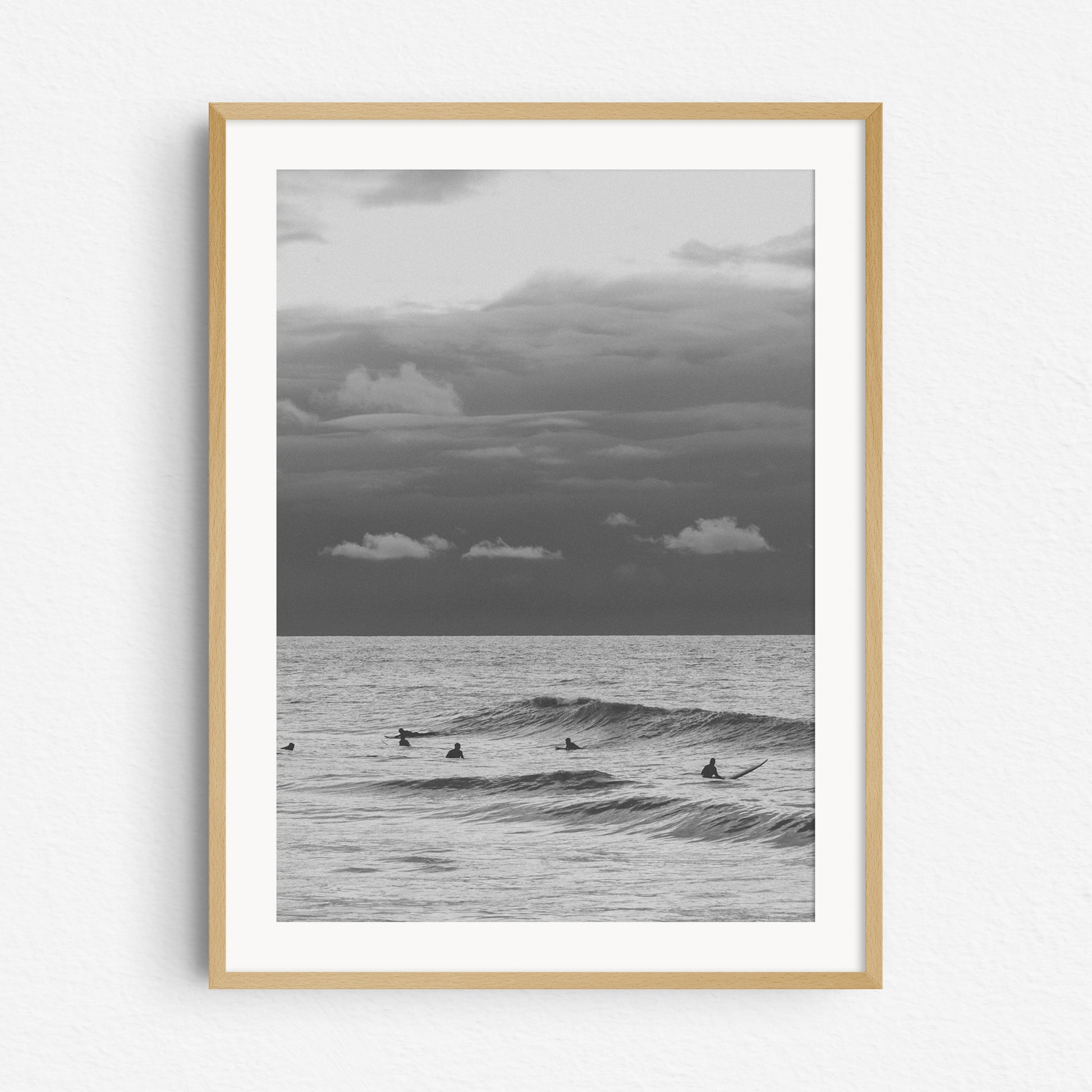 Black and white surf photo in a natural wooden frame.