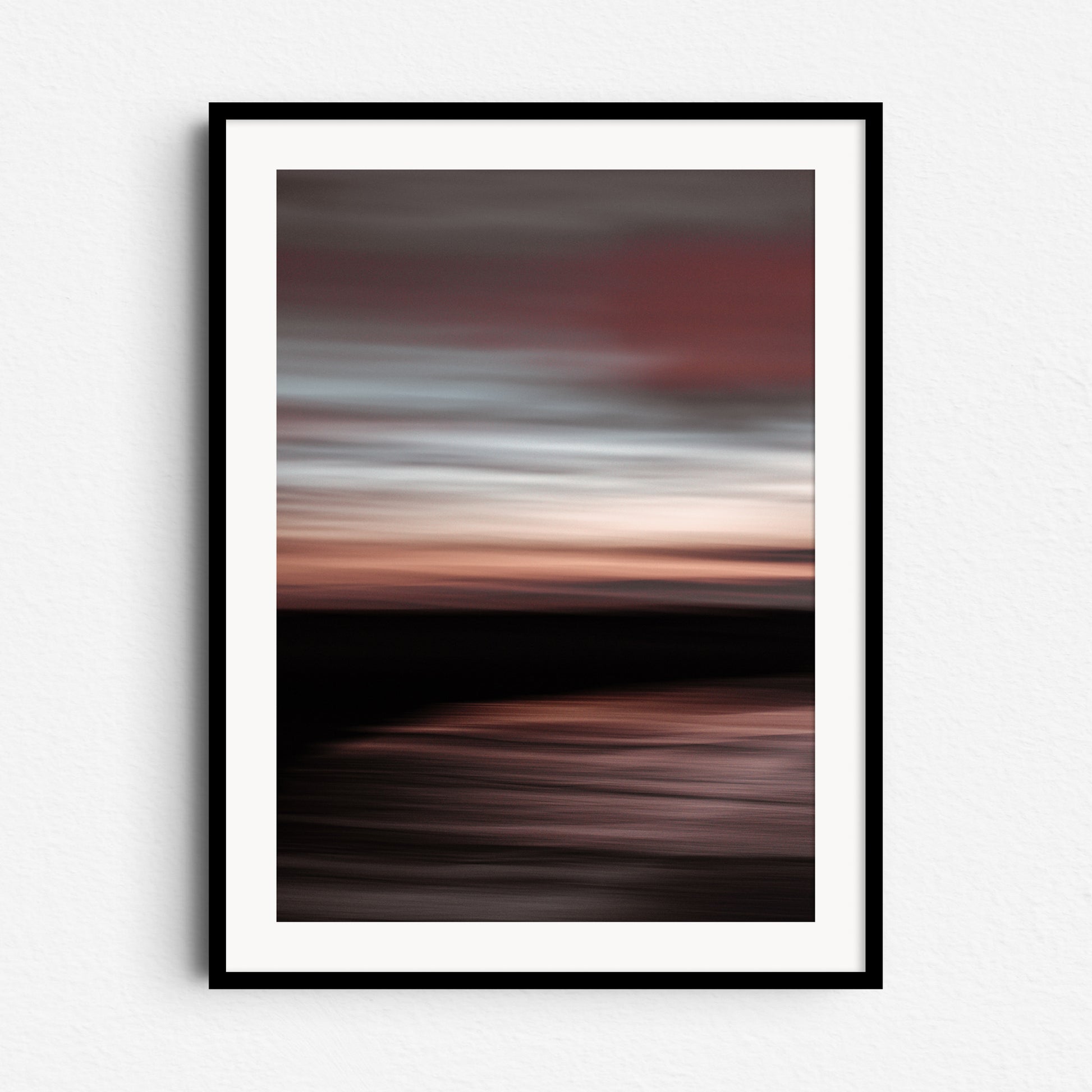 "Dawn" – abstract North Sea sunset with pastel reds and blues. Framed in black wood for dramatic, modern wall decoration.