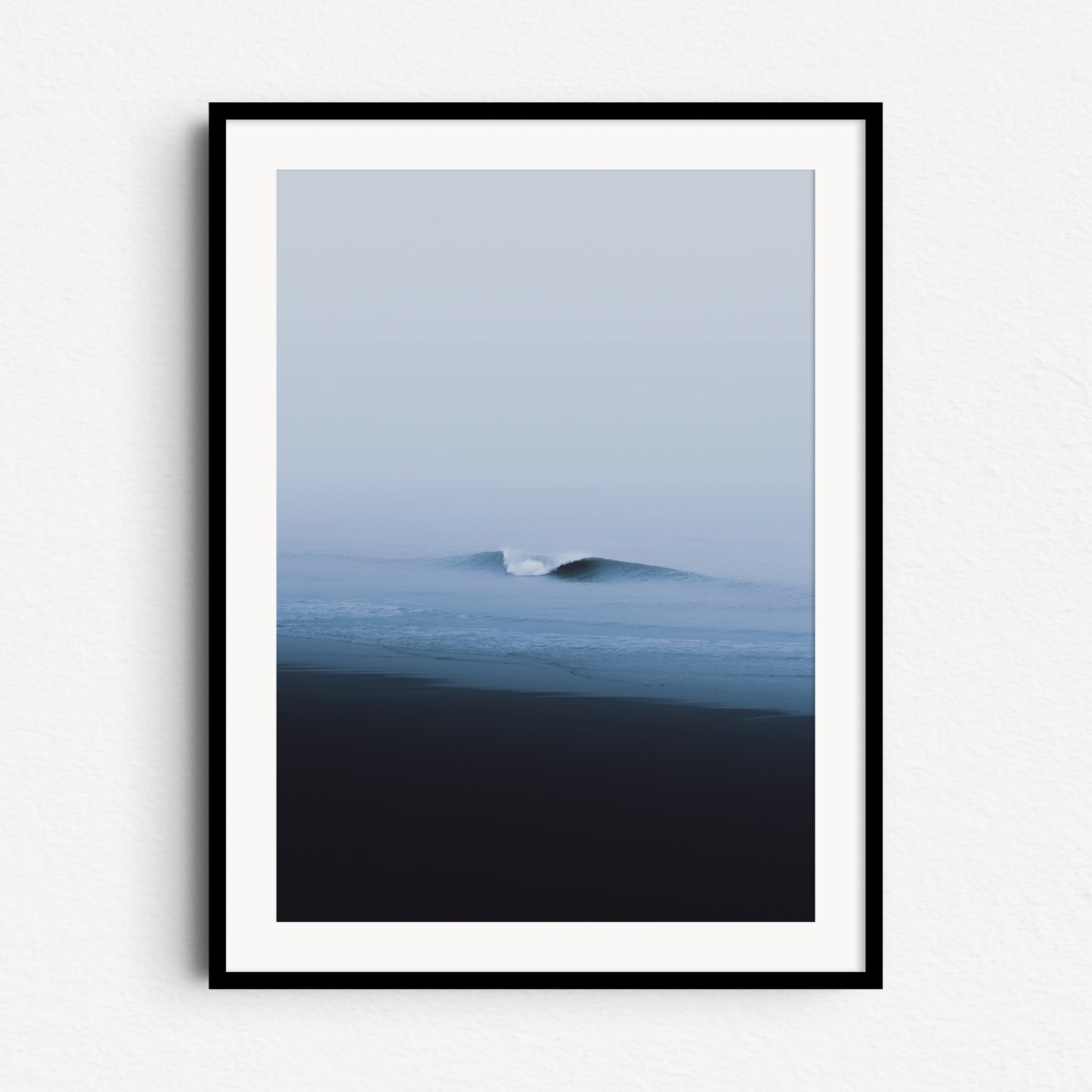 A calm North Sea photo of a perfect wave on a grey day. Framed in black wood for dramatic, modern artwork from The Hague.