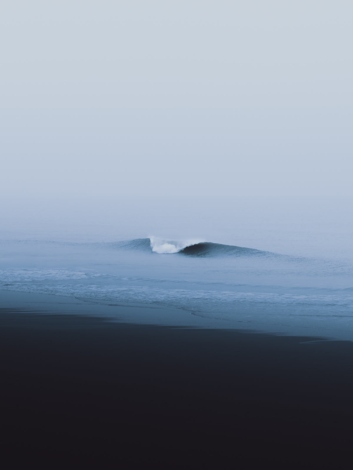 A minimalistic photo poster of a breaking wave on a Scheveningen beach in The Netherlands in a blue misty landscape.