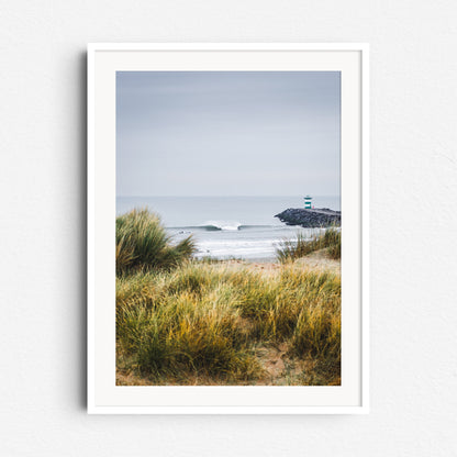 Colorful surf scene from Scheveningen, framed by dunes and surfers near the harbour. Framed in white wood for a fresh and calming wall decoration.