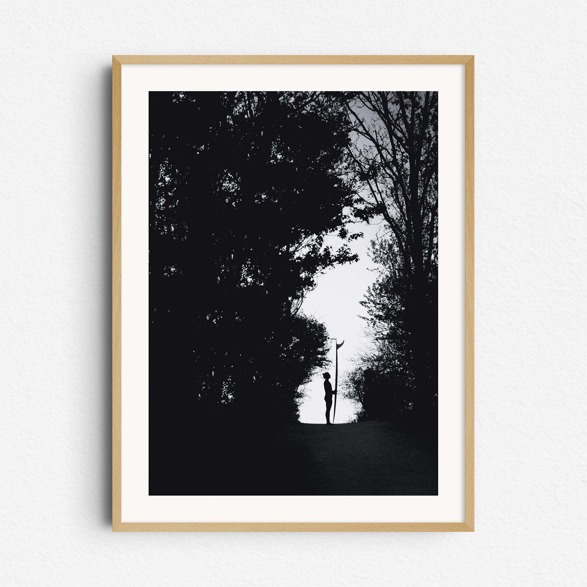 Silhouette of a female surfer with a longboard in a forest, framed in natural wood, a beautiful piece for Nature Photography lovers.