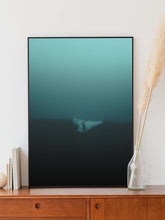 Afbeelding in Gallery-weergave laden, Surfer in a turquoise misty surf photo in the North Sea. Framed in a thin black aluminium frame placed on wooden desk.
