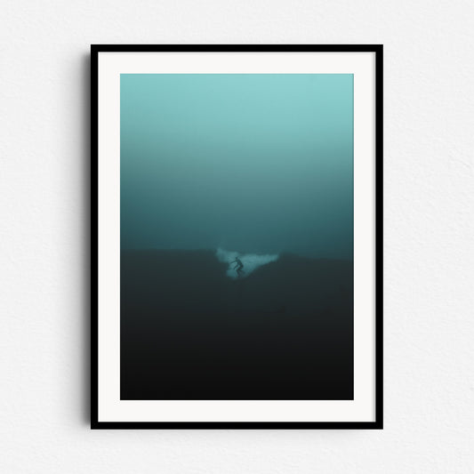 Silhouetted surfer on a misty Scheveningen morning in a turquoise haze. Framed in black wood for a bold, moody wall art piece.