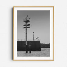 Load image into Gallery viewer, Black and white photo of a Dutch surfer standing in a harbour wall looking out at see. A serene photograph framed in natural wood, captured by Jop Hermans
