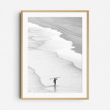 Load image into Gallery viewer, Peaceful black and white image of a surfer walking on the beach in The Hague, framed in natural wood for a warm, organic look. 
