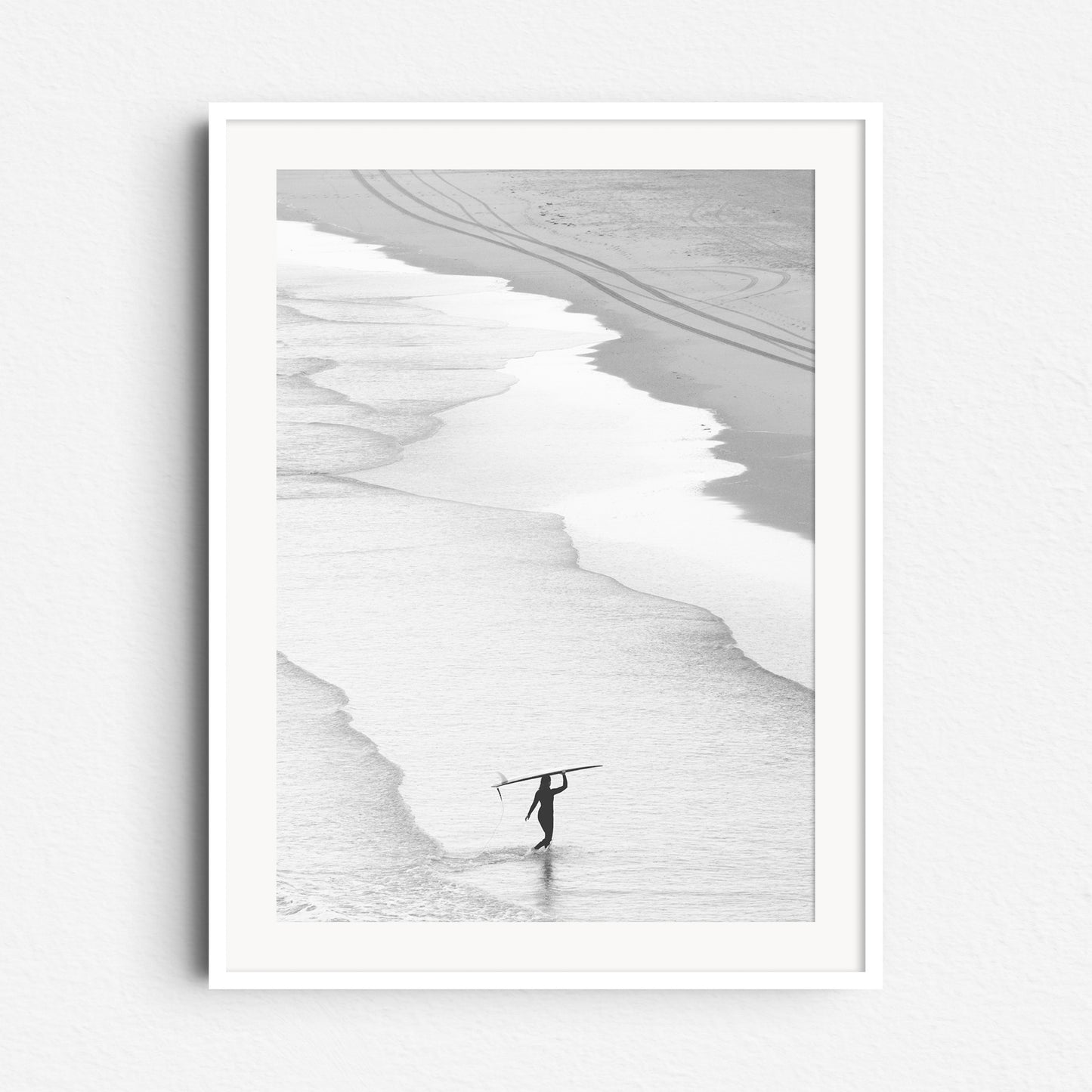 Serene surf photo with a woman carrying her longboard, framed in white wood to enhance the tranquil, minimalist vibe. Captured bij Jop Hermans