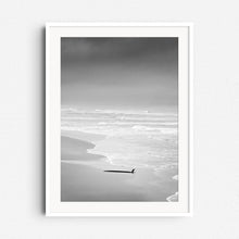 Load image into Gallery viewer, Serene black and white coastal scene in The Hague with a surfboard. The photo poster is framed in white wood, perfect for peaceful North Sea surf lovers.
