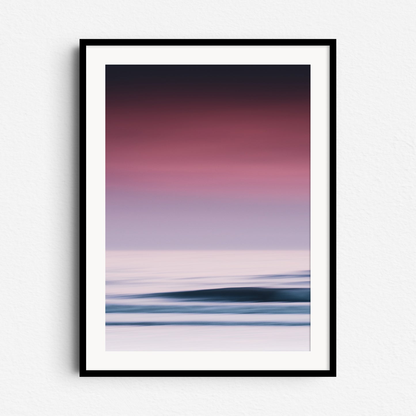 A vibrant abstract sea photo in purple hues. Long exposure adds a dreamy feel. Framed in black wood for bold, modern wall art.