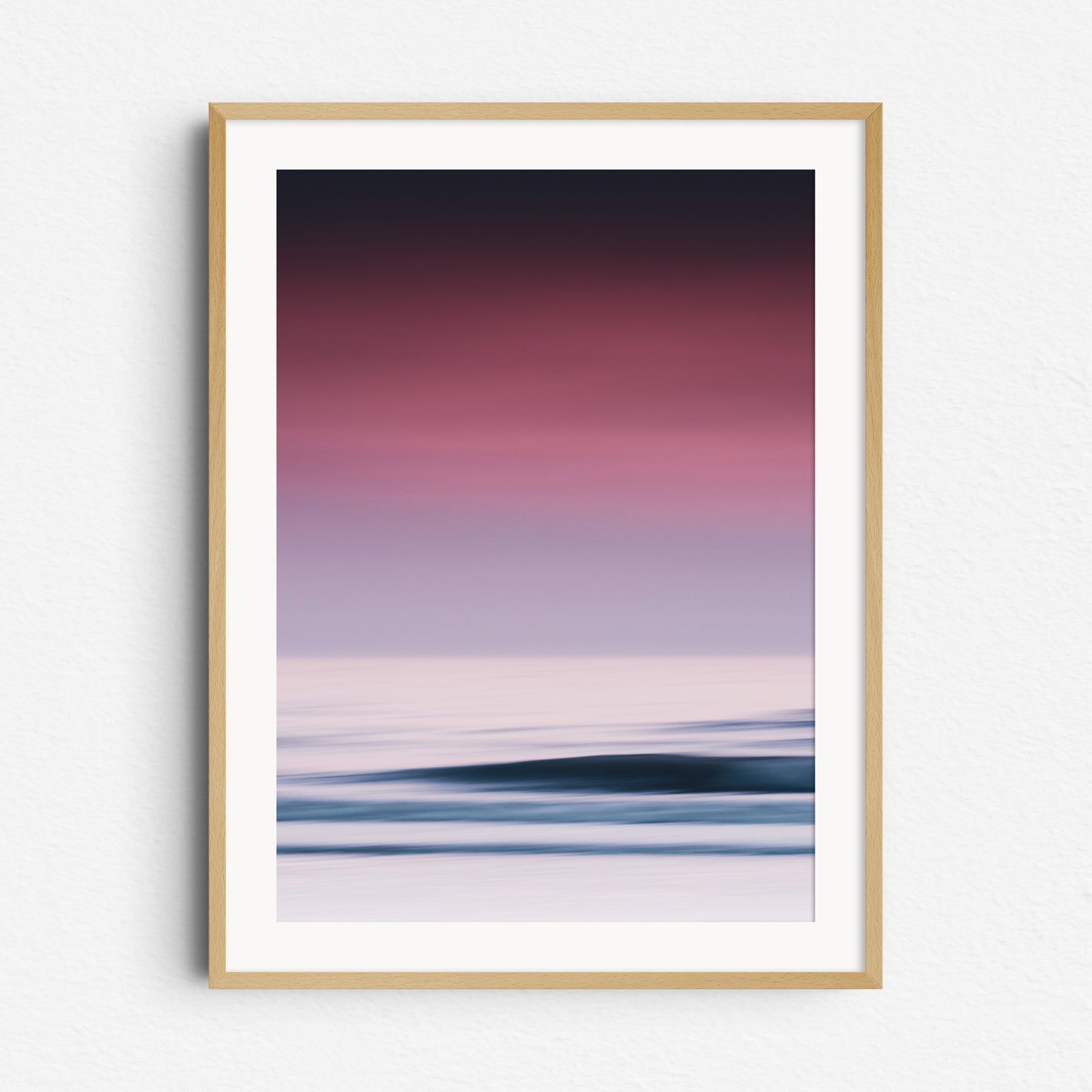 A vibrant sea photo with purple hues and bright water surfaces in The Hague. Framed in natural wood for a warm, organic touch.