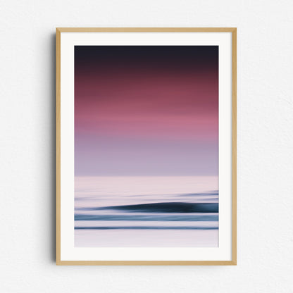 A vibrant sea photo with purple hues and bright water surfaces in The Hague. Framed in natural wood for a warm, organic touch.