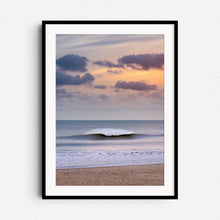 Load image into Gallery viewer, A dramatic North Sea wave breaks with bright spray under an orange sky in The Hague. Framed in black wood for bold, modern artwork.
