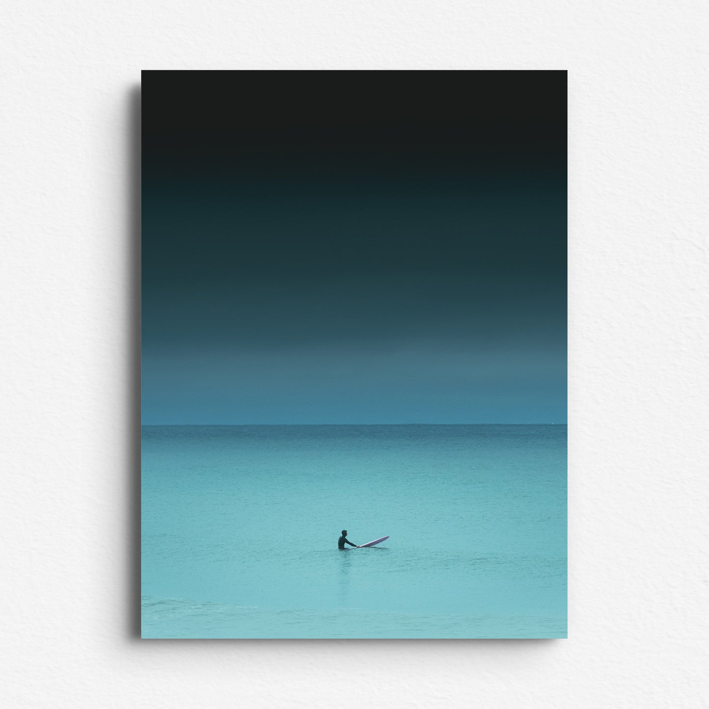 Turquoise-toned photo of a surfer facing the horizon in the North Sea. Photo poster printed on aluminium dibond. Perfect as decoration or art piece